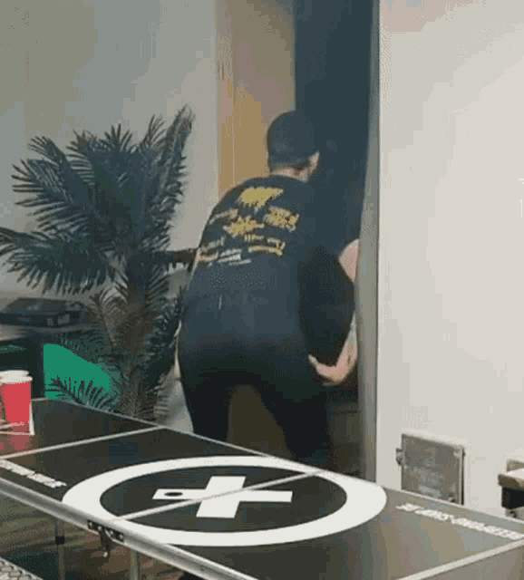 a man is standing in front of a ping pong table .