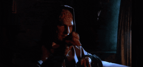 a man with a scary face is sitting in a chair