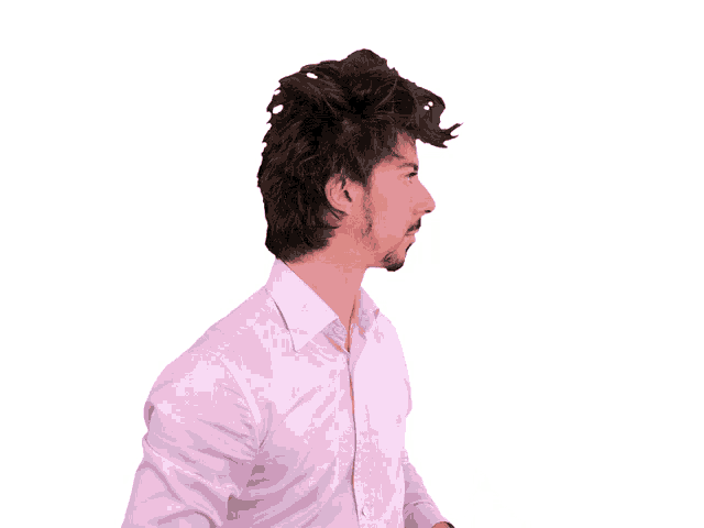 a man wearing a pink shirt is making a gesture with his hands