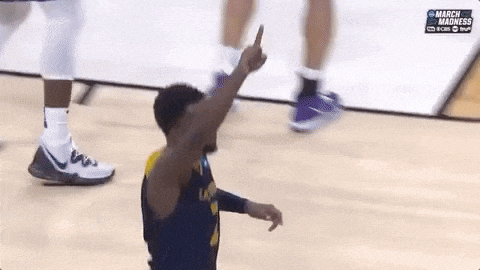 a basketball player is giving the middle finger during a march madness game .