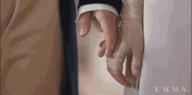 a close up of a person holding hands with the word emma on the bottom right