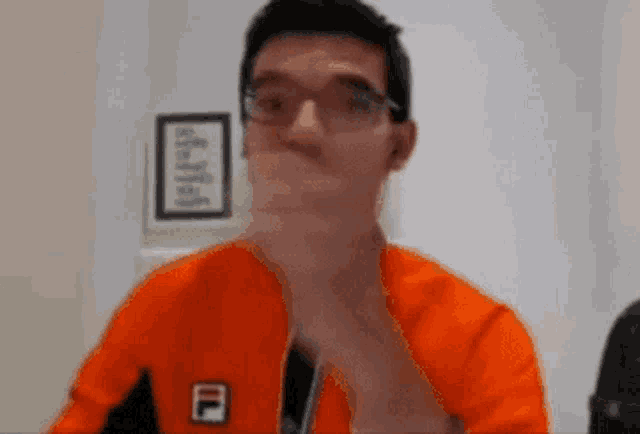 a man wearing glasses and an orange jacket with the letter f on it