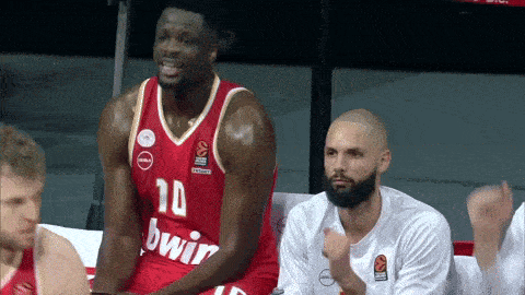 a basketball player wearing a number 10 jersey sits on the bench