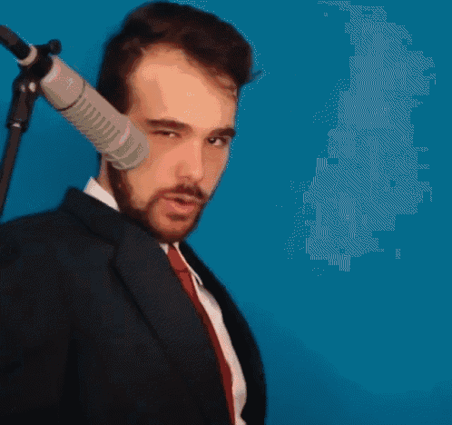 a man in a suit and tie is holding a microphone behind his ear