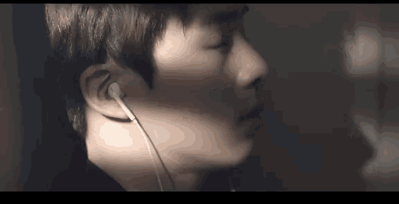 a close up of a man wearing earphones in a dark room .