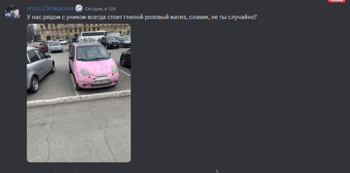 a pink car is parked in a parking lot next to a white car