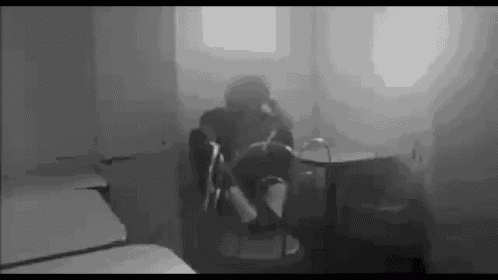 a man sits in a chair in a dark room