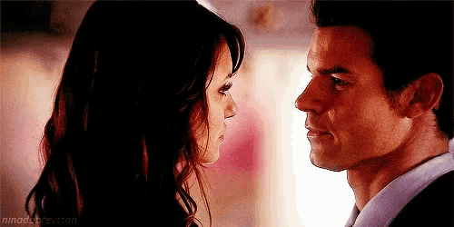 a man and a woman are looking at each other in a room .