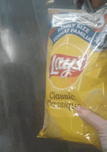 a person is holding a bag of lays chips in their hand