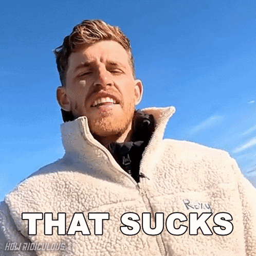 a man wearing a white jacket with the words that sucks written on it
