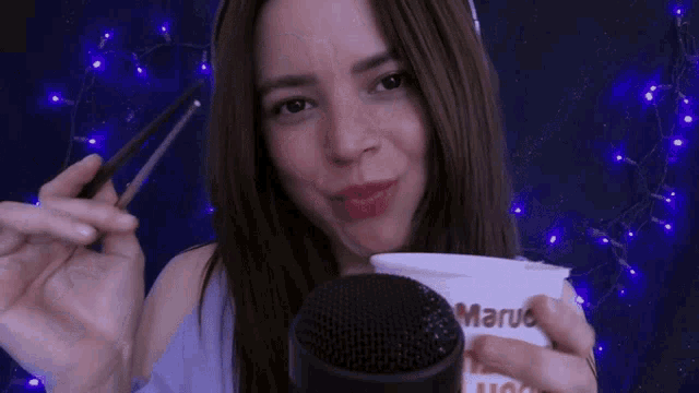 a woman is holding a cup that says marus on it