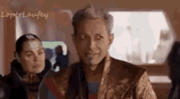 a man and a woman are standing next to each other in a room and the man is smiling .