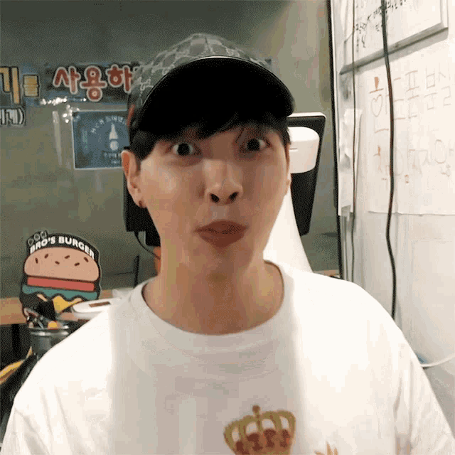 a man wearing a hat and a shirt that says bro 's burger makes a funny face