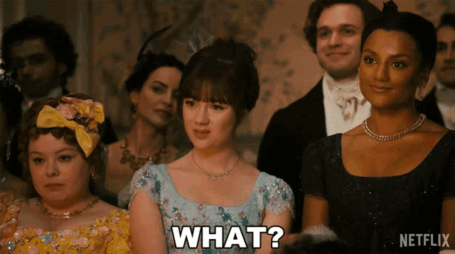 a woman in a blue dress says " what " in front of a crowd of people