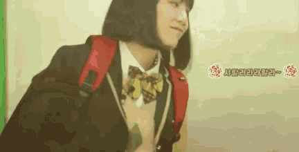a girl in a school uniform with a red backpack .
