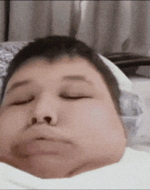 a close up of a person 's face with their eyes closed and their mouth open