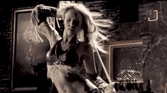a woman is dancing in a room with a brick wall