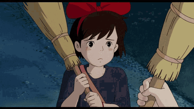 a girl with a red bow is holding a broom