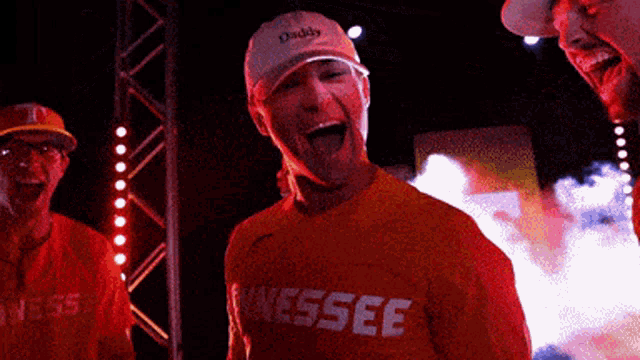 a man wearing an orange shirt that says tennessee is laughing