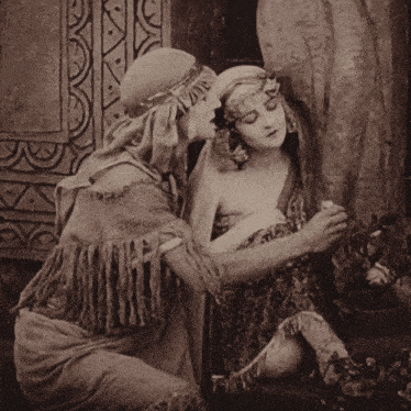 a black and white photo of a man kissing a woman on the forehead