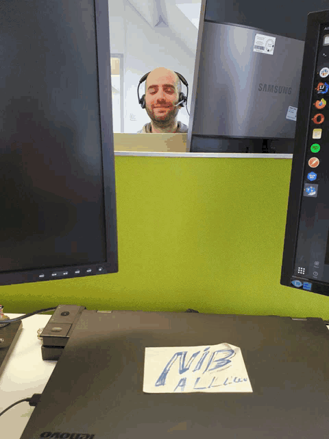 a man wearing headphones is behind a samsung monitor
