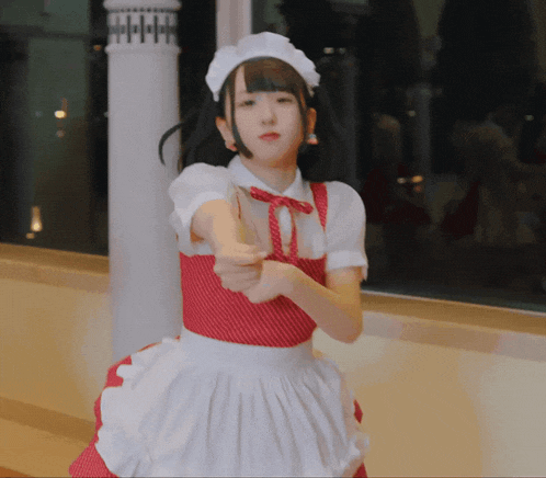 a girl in a red and white maid outfit is pointing at something