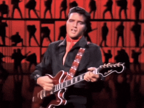 elvis presley is singing and playing a guitar