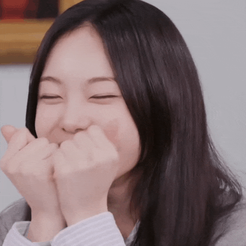 a young woman with her eyes closed and her hands on her face