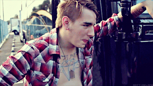 a man wearing a plaid shirt has a tattoo on his chest that says ' mattydelpop '