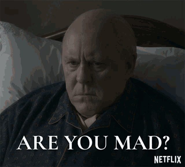 a man is laying in bed with the words " are you mad " written below him