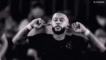 a man with a beard covering his ears with his hands
