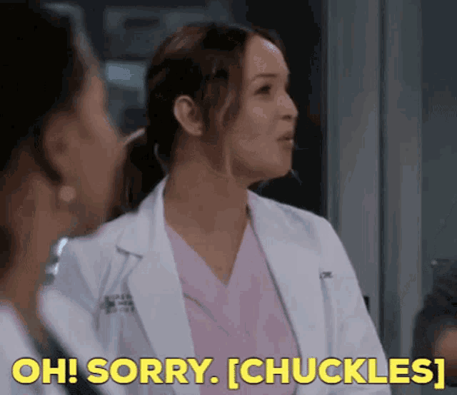 a woman in a white coat is talking to another woman in a pink scrub .