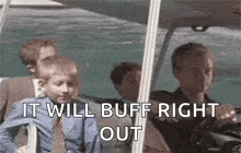 a group of people sitting on a boat with the words `` it will buff right out '' written on it .