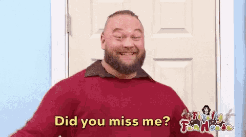 a man with a beard is standing in front of a door and says did you miss me .