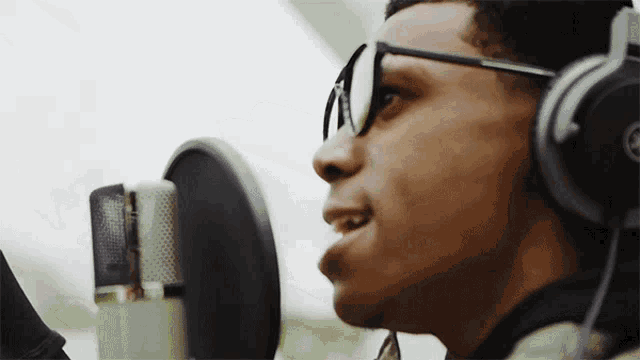 a man singing into a microphone with headphones on