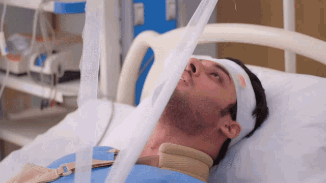 a man in a hospital bed has a bandage on his head