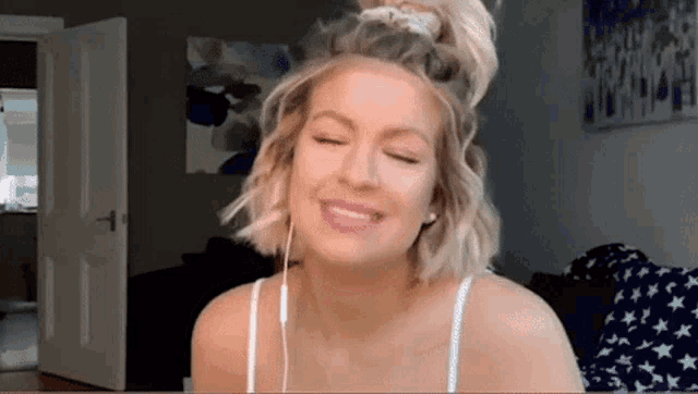 a woman wearing headphones and a ponytail is smiling