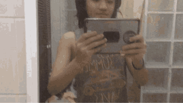 a person is taking a selfie in front of a mirror while wearing headphones .