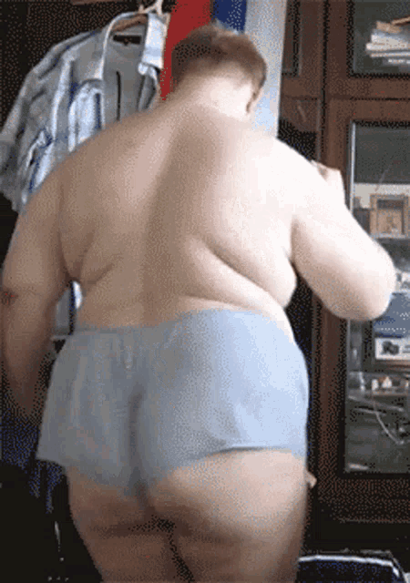 a man without a shirt is standing in a room