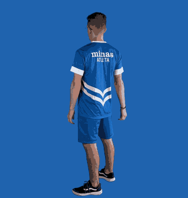 a man wearing a blue minas atleta shirt and shorts