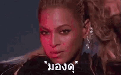a close up of a woman 's face with a ponytail and a foreign language .