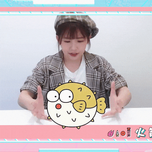 a woman sitting at a table with a cartoon puffer fish on it