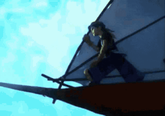 a person on a boat with a sail in the sky