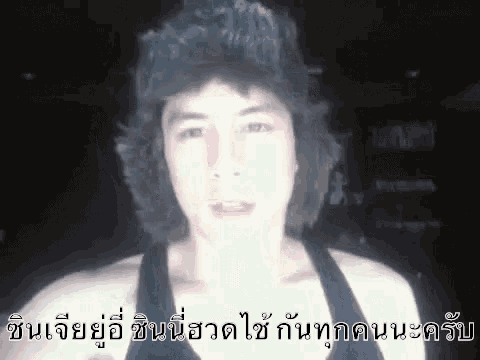 a man with a hat on his head is making a funny face in a video .