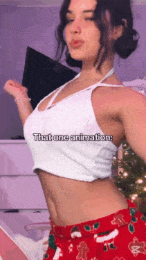 a woman in a white crop top and red pants is standing in front of a purple wall .