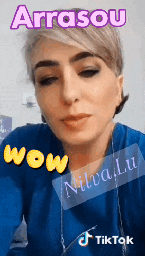 a woman wearing a blue shirt with the words arrasou wow nivaliu written on it