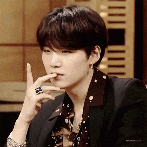 a close up of a person wearing a suit and a ring on their finger .