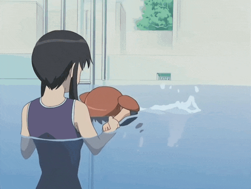 a girl in a purple tank top is standing in a swimming pool