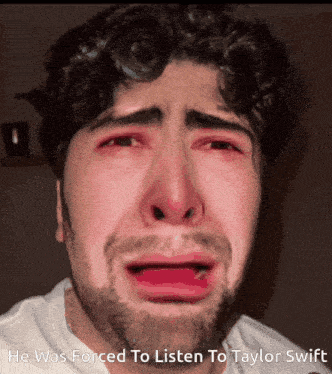 a man with a beard is crying with the words he was forced to listen to taylor swift
