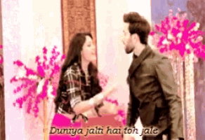 a man and a woman are standing next to each other with the words duniya jaiti hai ton jale written on the bottom